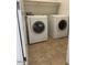 Laundry room features two white front loading washing machines and a shelf above at 24638 N 65Th Ave, Glendale, AZ 85310