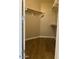 Empty walk-in closet with rod and shelves, and wood-look floors at 24638 N 65Th Ave, Glendale, AZ 85310