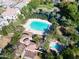 Aerial view of a community with a large pool, spa, pond, mature trees and luxury homes in the background at 2632 S Peppertree Dr # 104, Gilbert, AZ 85295