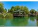 Picturesque gazebo on a pond surrounded by lush greenery, trees and a bridge, creating a serene outdoor space at 2632 S Peppertree Dr # 104, Gilbert, AZ 85295