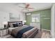 Bedroom with a sage green accent wall, ceiling fan, and large bed at 340 E Harwell Rd, Gilbert, AZ 85234