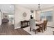 Well-lit dining room with a wooden table set, stylish chandelier, and seamless transition to adjacent living spaces at 36070 N Quiros Dr, San Tan Valley, AZ 85143