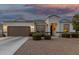 Charming single-story home featuring a well-manicured yard, neutral stucco, and inviting front entrance at 36070 N Quiros Dr, San Tan Valley, AZ 85143