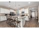 Bright kitchen featuring white cabinetry, granite countertops, stainless steel appliances, and a breakfast bar with seating at 36070 N Quiros Dr, San Tan Valley, AZ 85143