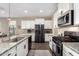 Modern kitchen showcasing stainless steel appliances, granite countertops, and white cabinetry at 36070 N Quiros Dr, San Tan Valley, AZ 85143