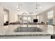 Modern kitchen features a granite counter island with seating, stainless steel sink and views of the open floor plan at 36070 N Quiros Dr, San Tan Valley, AZ 85143