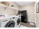 Laundry room featuring white washer and dryer, shelving, and a black refrigerator at 36070 N Quiros Dr, San Tan Valley, AZ 85143