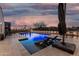 Inviting backyard pool with lounge chairs and umbrella, perfect for relaxation and outdoor enjoyment during dusk at 36070 N Quiros Dr, San Tan Valley, AZ 85143