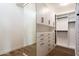 The walk-in closet has custom shelving, drawers, and ample storage space with hardwood floors at 37200 N Cave Creek Rd # 1035, Scottsdale, AZ 85262