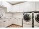 Well-lit laundry room with white cabinetry, countertop space, and modern washer and dryer at 37200 N Cave Creek Rd # 1035, Scottsdale, AZ 85262