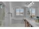 Bright bathroom featuring a soaking tub under an arched window and dual vanity with dark wood cabinets at 3777 E Latham Ct, Gilbert, AZ 85297