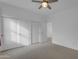 Bedroom featuring neutral carpet, white walls, a ceiling fan, and sliding closet doors for ample storage at 3777 E Latham Ct, Gilbert, AZ 85297