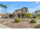 Charming two-story home featuring lush landscaping, a covered porch, and desert rock features at 3777 E Latham Ct, Gilbert, AZ 85297