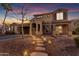 Inviting two-story home featuring warm exterior lighting, a stone walkway, and a well-maintained landscape at 3777 E Latham Ct, Gilbert, AZ 85297