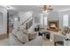 Cozy living room featuring a fireplace, a ceiling fan, and a staircase at 3777 E Latham Ct, Gilbert, AZ 85297