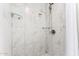 Modern shower stall featuring white marble-look tiles and glass shelving at 3832 W Eva St, Phoenix, AZ 85051