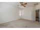 Spacious bedroom with carpet, ceiling fan, a large window, and a closet at 3894 E Palmer St, Gilbert, AZ 85298