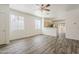 Bright living room with wood-look flooring, ceiling fan, and view of the kitchen at 3894 E Palmer St, Gilbert, AZ 85298