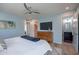 Comfortable main bedroom featuring a ceiling fan, blue accent wall, and a connecting bathroom with a blue-and-red tile floor at 406 W Flower St, Phoenix, AZ 85013