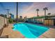 Outdoor in-ground pool surrounded by lush landscaping and mature palm trees at 406 W Flower St, Phoenix, AZ 85013