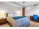 Bedroom with a ceiling fan, two lamps, a blue throw blanket, and a wooden desk at 41353 N 106Th St, Scottsdale, AZ 85262