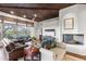 Comfortable living room with a fireplace, wood ceiling, large windows, and an entertainment center at 41353 N 106Th St, Scottsdale, AZ 85262
