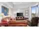 Comfortable living room with leather furniture, entertainment center, and large windows providing natural light at 41353 N 106Th St, Scottsdale, AZ 85262