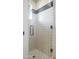 Shower with white tiled walls, a window, and a glass door with chrome handle at 41353 N 106Th St, Scottsdale, AZ 85262