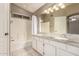 Bright bathroom with double sink vanity featuring granite counters and a tiled shower-tub combo at 4148 E Coolbrook Ave, Phoenix, AZ 85032