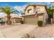 Exterior showcasing a two-car garage and drought tolerant landscaping with stone mulch and palm trees at 4148 E Coolbrook Ave, Phoenix, AZ 85032