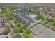 An aerial view showcases lush landscaping, tennis courts, pool, and a well-maintained park at 44125 W Cydnee Dr, Maricopa, AZ 85138