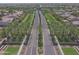 An aerial view showcases a lush community with mature trees lining the road, and well-manicured lawns at 44125 W Cydnee Dr, Maricopa, AZ 85138