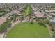 The aerial shot shows a lush park area with mature trees, walking paths, and green grass at 44125 W Cydnee Dr, Maricopa, AZ 85138