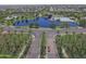 Aerial view of a Primary planned community with lush greenery and a beautiful community pool and lake at 44125 W Cydnee Dr, Maricopa, AZ 85138