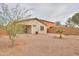Low-maintenance backyard with rock landscaping, privacy fence, and partial patio cover at 44125 W Cydnee Dr, Maricopa, AZ 85138