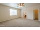 A bright bedroom with carpet flooring, an ensuite bathroom and walk-in closet at 44125 W Cydnee Dr, Maricopa, AZ 85138