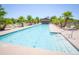 Relaxing community pool featuring lounge chairs, palm trees, and a shaded cabana on a sunny day at 44125 W Cydnee Dr, Maricopa, AZ 85138