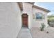 Covered front entrance with a solid wood door and desert landscaping at 44125 W Cydnee Dr, Maricopa, AZ 85138