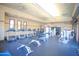 Well-equipped gym with treadmills, elliptical machines, weight benches, and TV screens for a complete workout at 44125 W Cydnee Dr, Maricopa, AZ 85138