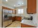 Bright kitchen featuring stainless steel refrigerator and oak cabinets at 44125 W Cydnee Dr, Maricopa, AZ 85138