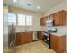 Well-lit kitchen with stainless steel appliances, oak cabinets, and tile floors at 44125 W Cydnee Dr, Maricopa, AZ 85138
