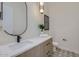 Stylish powder room features a modern sink, decorative mirror, and patterned tile flooring at 4640 E Glenrosa Ave, Phoenix, AZ 85018