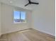 Minimalist bedroom with hardwood floors, ceiling fan, and a window offering natural light and neighborhood views at 4640 E Glenrosa Ave, Phoenix, AZ 85018