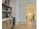 Hallway with custom cabinetry, open shelves, drink fridge and modern light fixture leading to the stairs at 4640 E Glenrosa Ave, Phoenix, AZ 85018