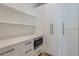 Bright pantry features white cabinets, drawers, stone countertop, open shelves and a stainless steel microwave at 4640 E Glenrosa Ave, Phoenix, AZ 85018