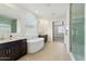Bright bathroom featuring dual vanities, freestanding tub, walk-in shower with tiled walls, and wood-look tile flooring at 5046 W Karl St, San Tan Valley, AZ 85144