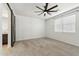 Neutral bedroom with a ceiling fan, carpet floors, a window with blinds and a sliding barn door to the bathroom at 5046 W Karl St, San Tan Valley, AZ 85144