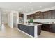 A kitchen features dark cabinets, stainless steel appliances, a large island, and wood-look tile floors at 5046 W Karl St, San Tan Valley, AZ 85144