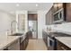 A kitchen features dark cabinets, stainless steel appliances, granite countertops, and wood-look tile floors at 5046 W Karl St, San Tan Valley, AZ 85144