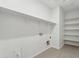 The laundry room has white shelving, tile floors, and hookups for a washer and dryer at 5046 W Karl St, San Tan Valley, AZ 85144